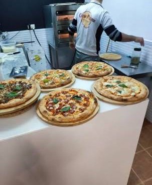 Pizzas recién hechas en el mostrador de Casa Pizza